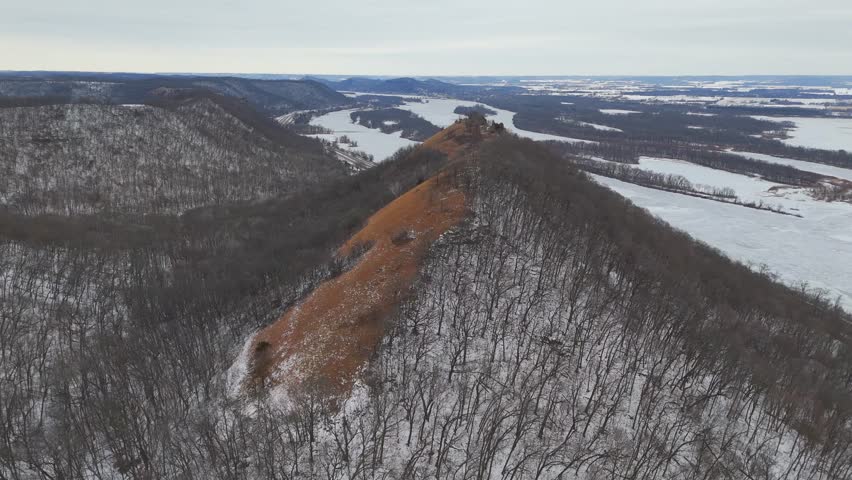 The bluffs around Winona rise above a frozen river valley, showcasing the dramatic winter terrain of Minnesota’s Driftless Region.