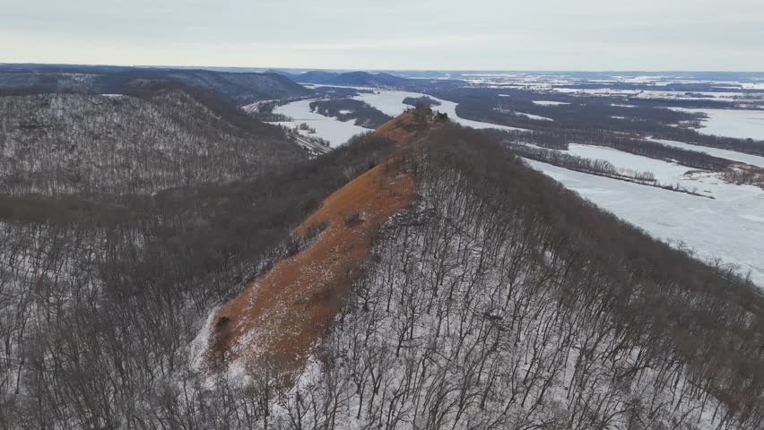 An expansive winter panorama captures the rugged bluffs of southeastern Minnesota, with the Mississippi River winding through the Driftless Area.