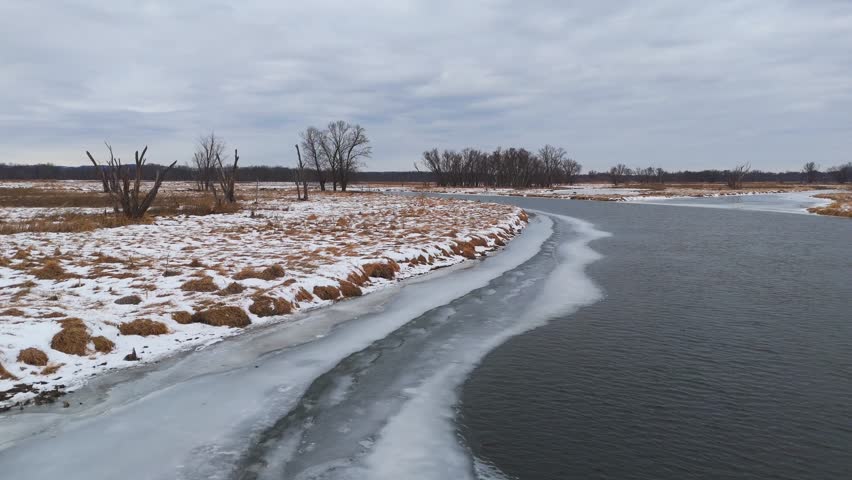 Winter stillness fills the Driftless landscape as frozen river channels wind past small islands of leafless forest.