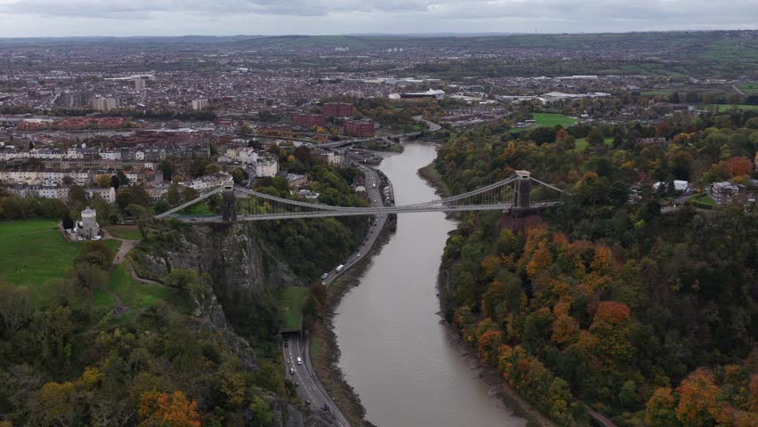 Aerial drone video of the iconic Clifton Suspension Bridge spanning the Avon Gorge in Bristol, a masterpiece of Victorian engineering by Isambard Kingdom Brunel.