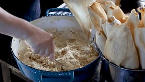 Woman's hands spreading masa dough on a corn husk to make traditional tamales in a rustic kitchen - Powered by Shutterstock - Get 15% off with code: PIKWIZARD15