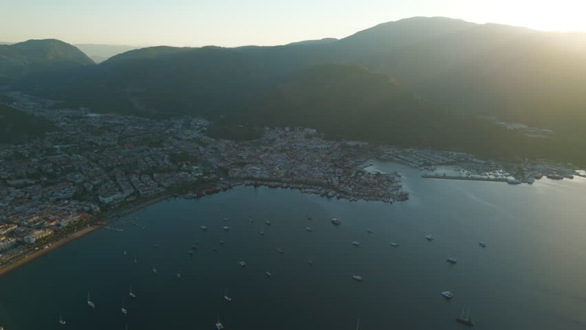 Marmaris, Turkey. Bay with yachts, beaches and promenade in morning. City lies in cool shadow from mountains while sea basks in sunlight. Aerial View