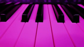 Electronic piano keyboard keys are shown in a close-up, low-angle view. Multicolored club-style lights cycle through pink, blue, and green, creating a vibrant and dynamic mood. - Powered by Shutterstock - Get 15% off with code: PIKWIZARD15