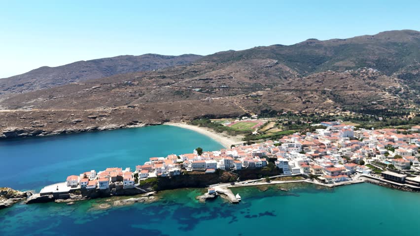 Andros Chora peninsula with harbor and hillside town, Andros Island, Greece, aerial view