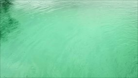 Rain droplets ripple across a swimming pool surface, creating calming patterns and a serene, refreshing atmosphere - Powered by Shutterstock - Get 15% off with code: PIKWIZARD15