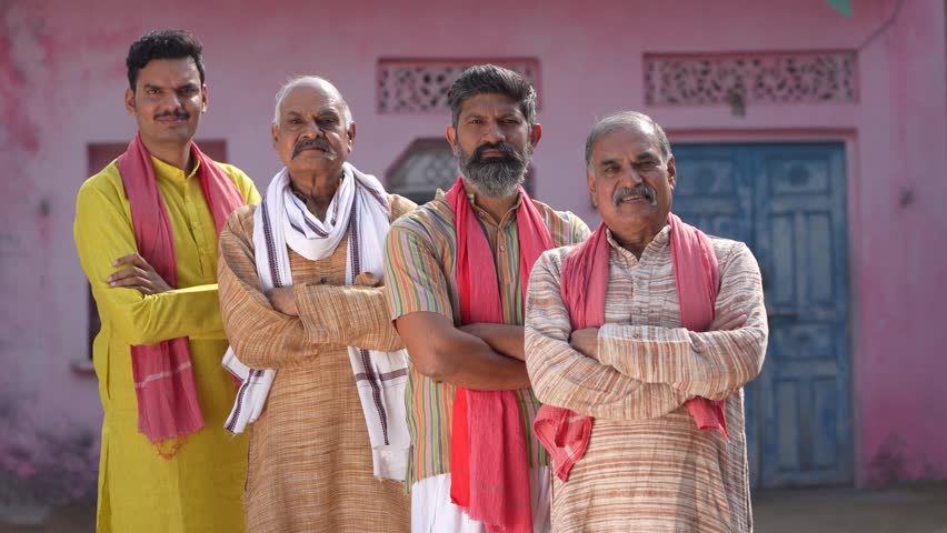 indian farmers standing confidently at in front of home 
