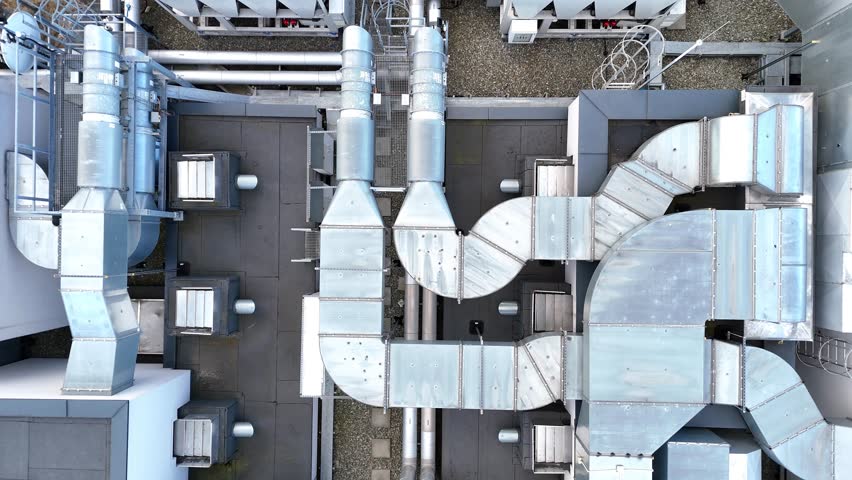 Aerial view of industrial rooftop showcasing extensive HVAC system with interconnected ducts, vents, and units demonstrating complex engineering and design in a modern facility layout
