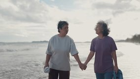 Asian mature LGBTQ couple walking together on a sunny beach by the sea during a romantic vacation - Powered by Shutterstock - Get 15% off with code: PIKWIZARD15