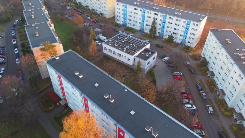 Aerial view of apartment buildings with cars parked along the street, creating a vibrant urban scene with autumn colors, Gdansk, Pomeranian Voivodeship, Poland.