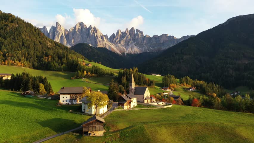 Aerial view of the picturesque St. Magdalena Church nestled amidst verdant hills, framed by the majestic Dolomites, St. Magdalena, Trentino-South Tyrol, Italy.