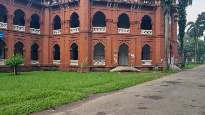 Historic Curzon Hall in Dhaka, Bangladesh, once a town hall and now part of the university, shown from outside beneath a hazy, smog-filled grey sky