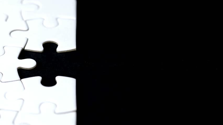 last piece of white plain jigsaw filling by female hand, step of success concept Hand putting last piece of puzzle Solution, planning,