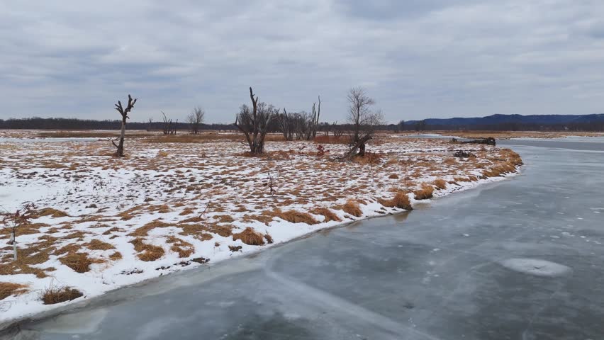 The Driftless Area in winter features slow, frozen rivers weaving around wooded islands under a pale seasonal sky. Minnesota Wisconsin boarder