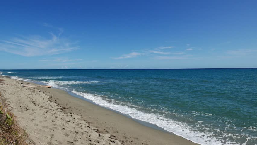 Sea surf on a sandy beach in Corsica.