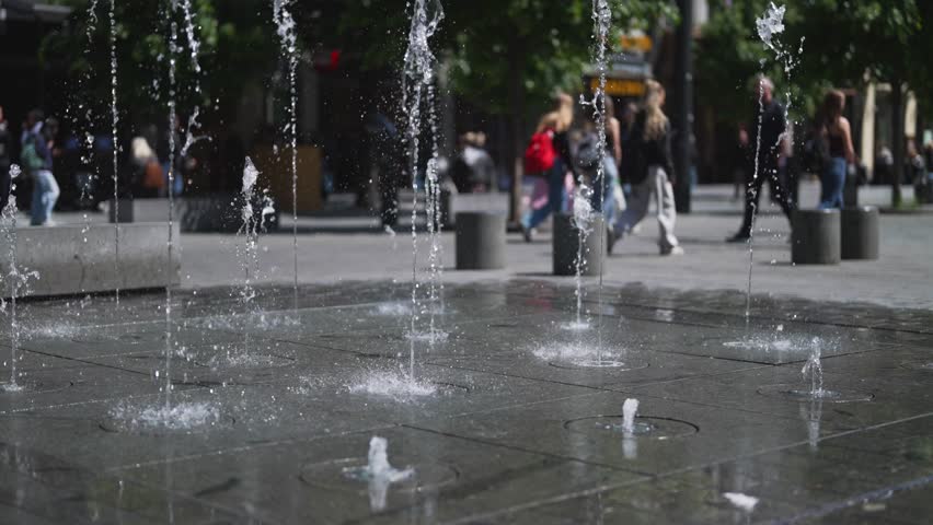 Modern water fountains on a city square.