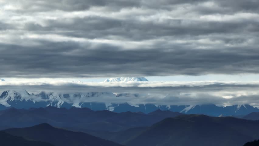 Aerial footage landscape of foggy snow capped mountains in sichuan, China