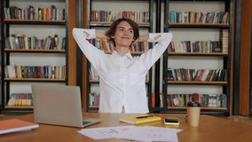 Young smiling happy cheerful successful employee business woman she wears white shirt casual clothes stretch hands take break rest sit work at office desk with pc laptop. Achievement career concept - Powered by Shutterstock - Get 15% off with code: PIKWIZARD15