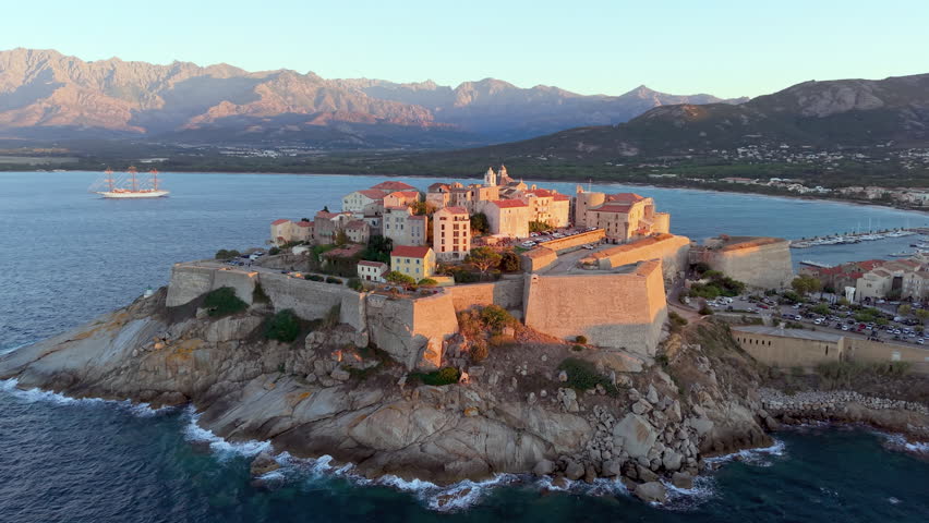 Aerial view of calvi citadel at sunrise with serene waters. Fortress with marina. Corsica. France