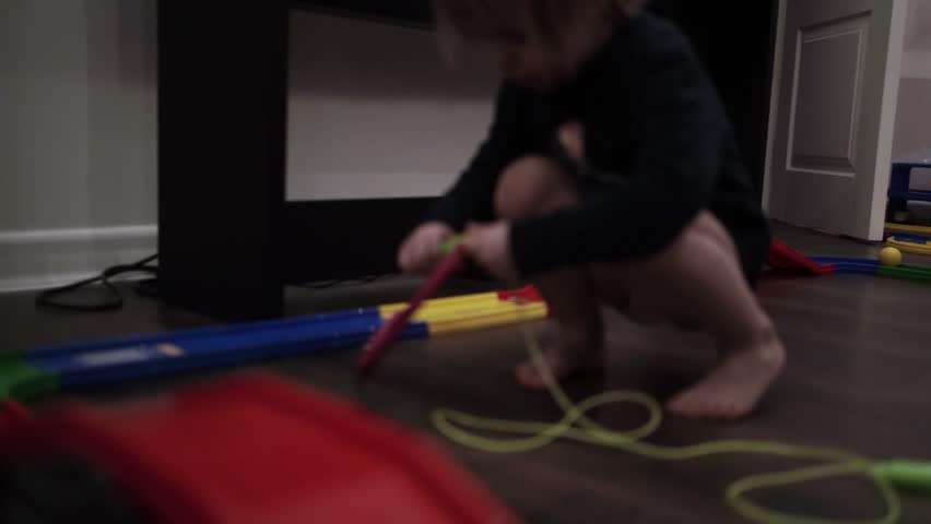 Toddler Girl Playing with Jump Rope at Home Indoors
