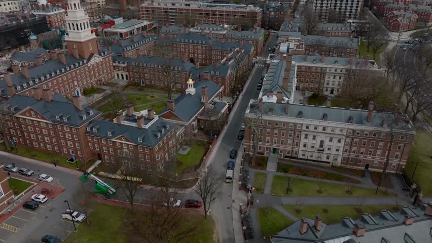 Aerial ascending view of historic red brick buildings at Harvard University campus in Boston, USA, highlighting iconic architecture and academic heritage.