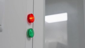 Close-up of an illuminated red indicator above a green button on a sleek industrial control panel, signaling operational status in a clean laboratory environment with reflective glass surfaces - Powered by Shutterstock - Get 15% off with code: PIKWIZARD15