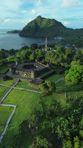 Drone view diagonally across Fort Belgica, revealing its structure, inner yard and alignment with the city of Banda Neira.