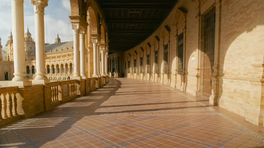 Walking through corridors of the historic Seville trade exhibition and conference building, showcasing ancient architecture in the city center, Spain.