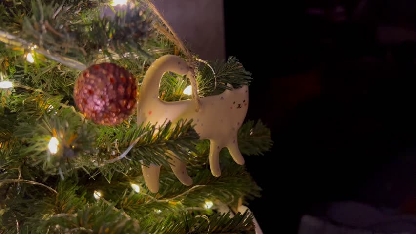Christmas ceramic animal ornaments on a Christmas tree with lights close-up as a background