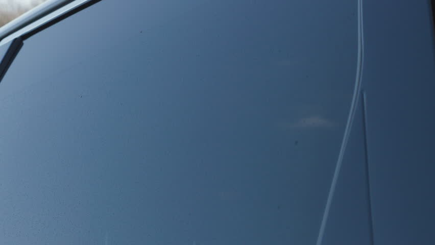 Car rear window automatic lowering with clean electric motor sound, close up side view of glass sliding down on parked vehicle