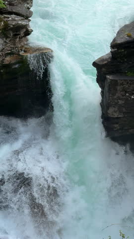 Rushing waterfall cascading through rocky canyon gorge