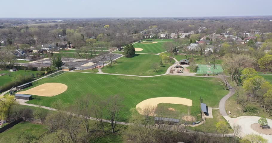 Aerial view of a sports field with baseball diamonds, a softball diamond and pickleball courts.