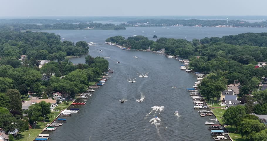 Aerial footage capturing motorized power boats navigating the scenic Fox River within the Chain O