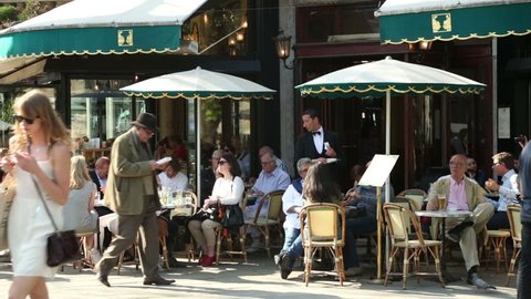 PARIS - APRIL 26: Unidentified people sit at Paris cafe, Deux Magots on April 26, 2013 in Paris. Intellectuals and writers like Jean-Paul Sartre and Ernest Hemmingway were patrons of this famous cafe.