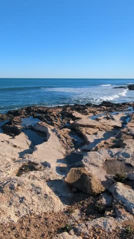 Rocky seashore, small waves in the soft light of the setting sun.