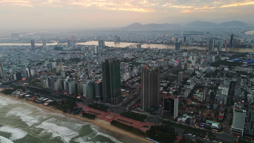 Aerial of Vietnam Da Nang city center, My Khe beach , city between the Han River and the East Sea, with bridges linking the bustling districts. drone at sunset