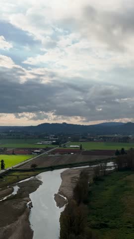 Winding River in a Scenic Green Valley with Farmland, British Columbia, Canada