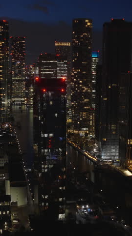 Vertical aerial view of Canary Wharf in London at night. Illuminated financial district located on the Isle of Dogs
