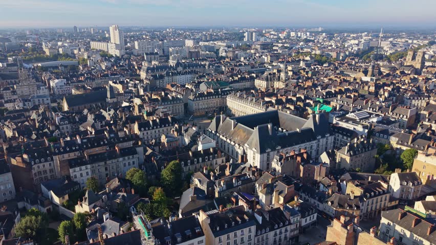 Drone pull-away frames Rennes historic city center with Parlement Bretagne, Town Hall Opéra monument, Palais Commerce and integrated dense medieval Renaissance architecture Brittany, France.​