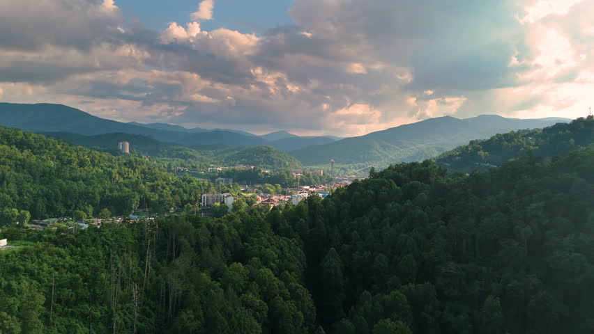 Aerial panorama of Gatlinburg, Tennessee with observation tower, town tourist infrastructure and Smoky Mountains National Park nearby.
