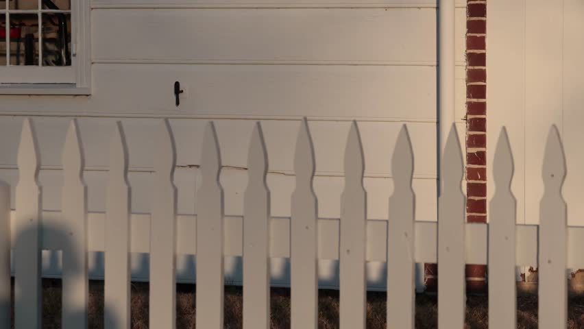 Solomons, Maryland, USA A white picket fence in the setting sun. 