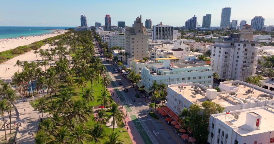 Ocean Drive street in Miami Beach. American iconic travel destination. Florida road with walking pedestrians and moving traffic cars.
