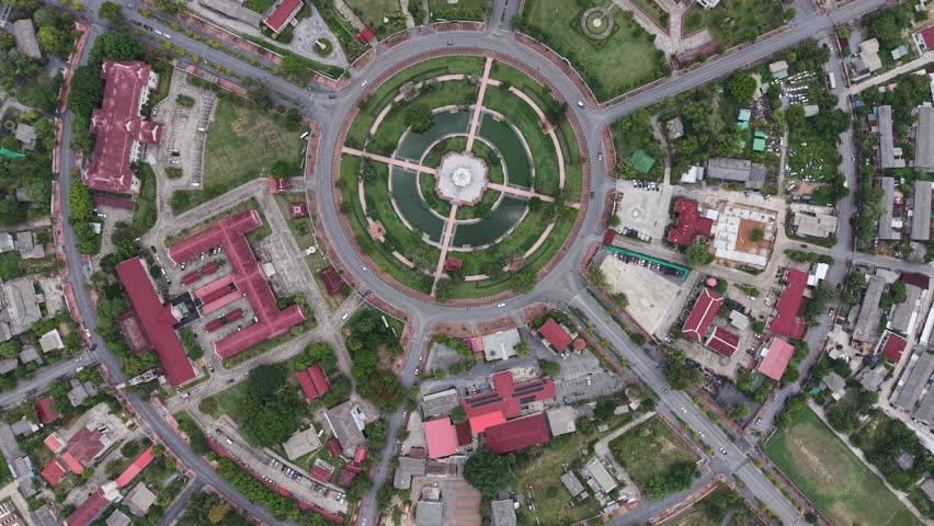Cinematic drone footage showcasing the circular roundabout park of the City Pillar Shrine amidst the well-organized urban layout of Yala.