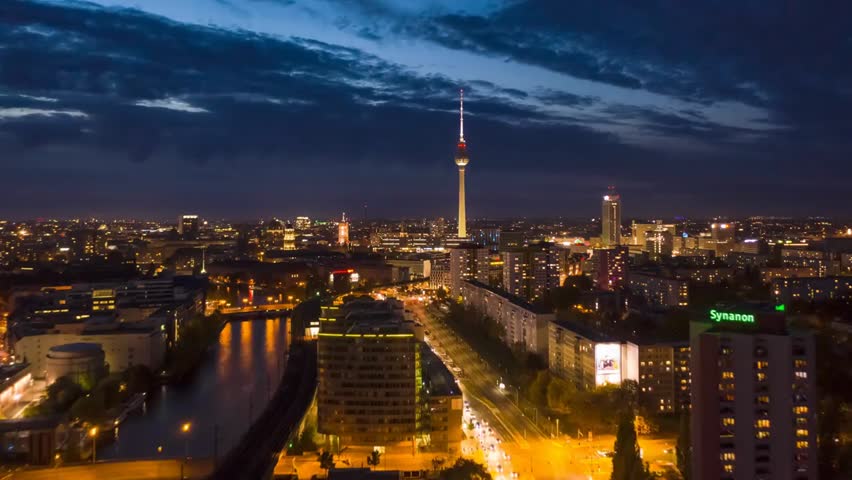"Aerial hyperlapse of Berlin at night, showcasing Alexanderplatz, the TV Tower, city lights, and dynamic urban motion in a stunning time-lapse view."