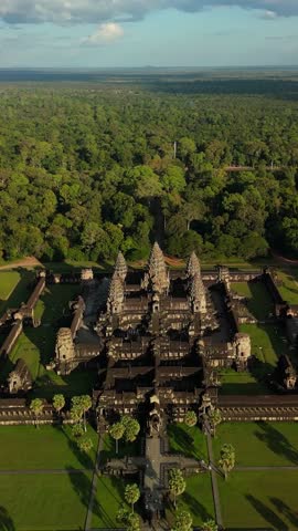 Vertical drone ascends and pulls back above Angkor Wat, showing the causeway, moat, and forest near Siem Reap