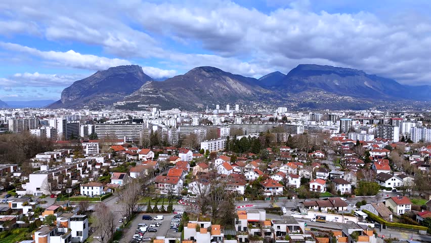 Aerial Grenoble mixed housing neighborhood with geometric homes and Alps