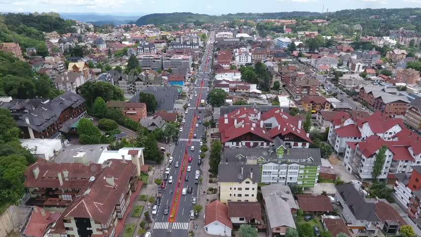 Cinematic drone aerial rising reveal establishing shot of Gramado city center main avenue and European architecture in Rio Grande do Sul Brazil. High quality 1080p 60fps video.