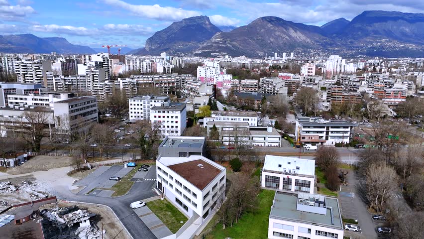 Aerial drone view of Grenoble apartments with colorful facades and Alps