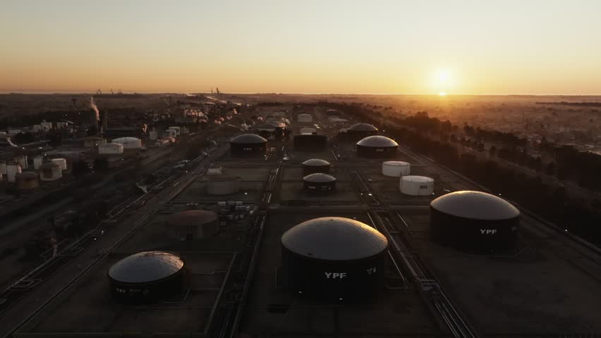 Sunset view of oil facility and industrial energy plant, showing energy production