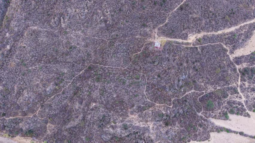 Overhead view of rural land with patchy vegetation and dirt paths