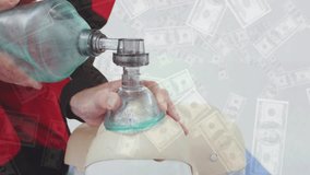 Animation of banknotes over caucasian male paramedic using oxygen mask on mannequin. Global medicine and digital interface concept digitally generated video. - Powered by Shutterstock - Get 15% off with code: PIKWIZARD15